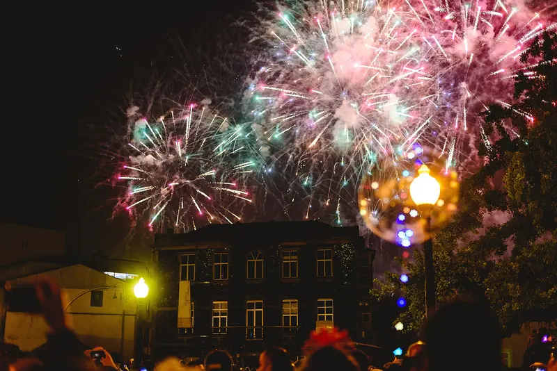 Fogo de artifício sobre a multidão numa noite de arraial
