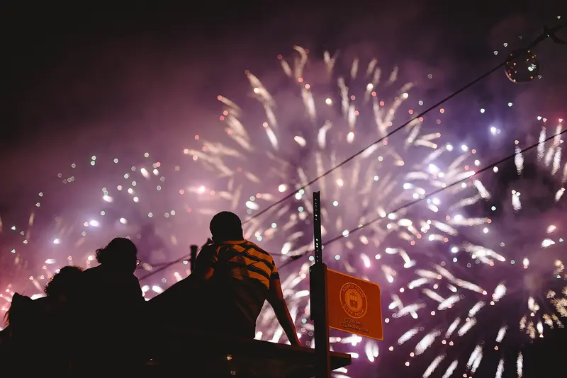 Pessoas a ver o fogo de artifício numa noite de festa