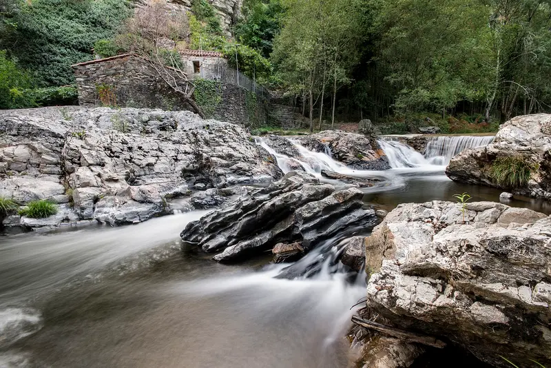 Rio Sousa a correr entre penedos de granito na Senhora do Salto, com um moinho ao fundo